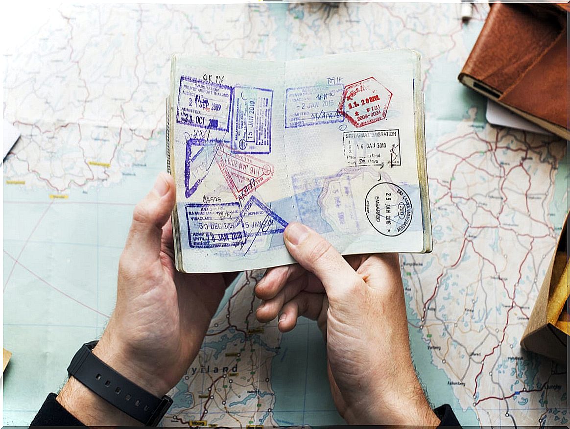 A passport full of stamps in the hands of a traveler.