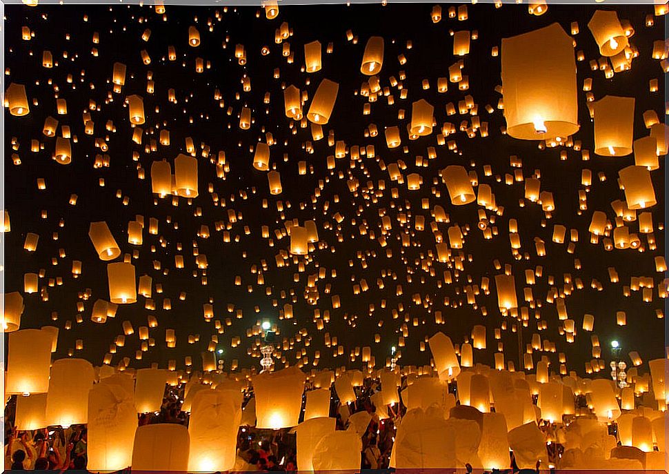 People throwing lanterns in Yi Peng